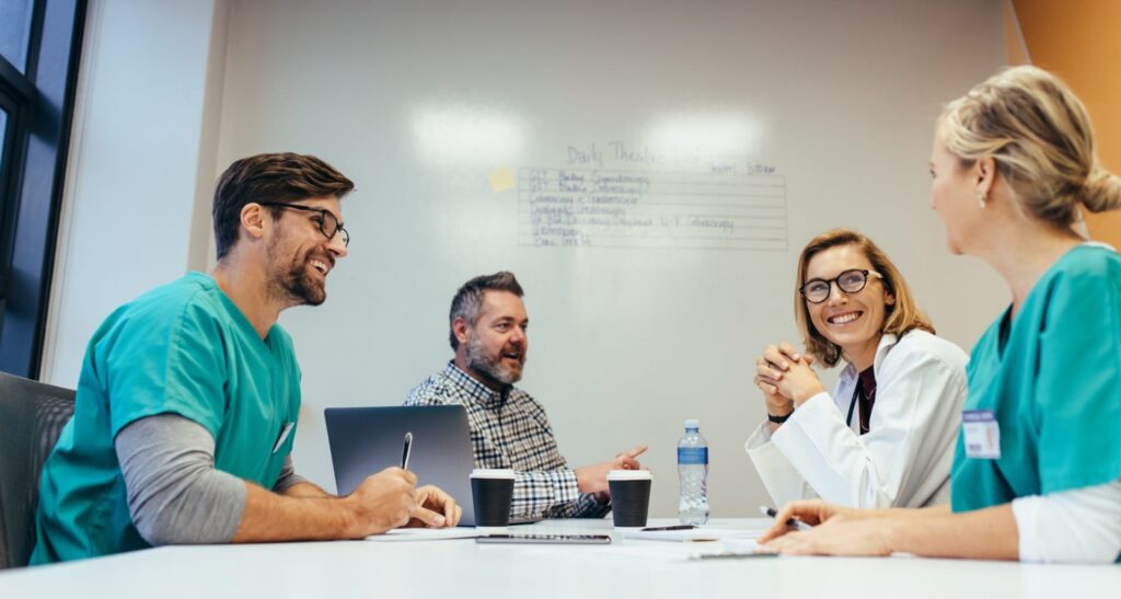 Medical professionals collaborating in a small meeting room.