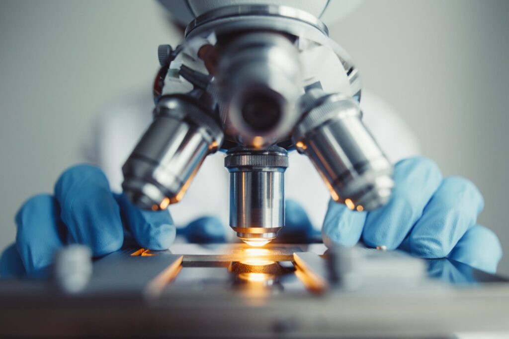 Researcher placing a slide under a microscope